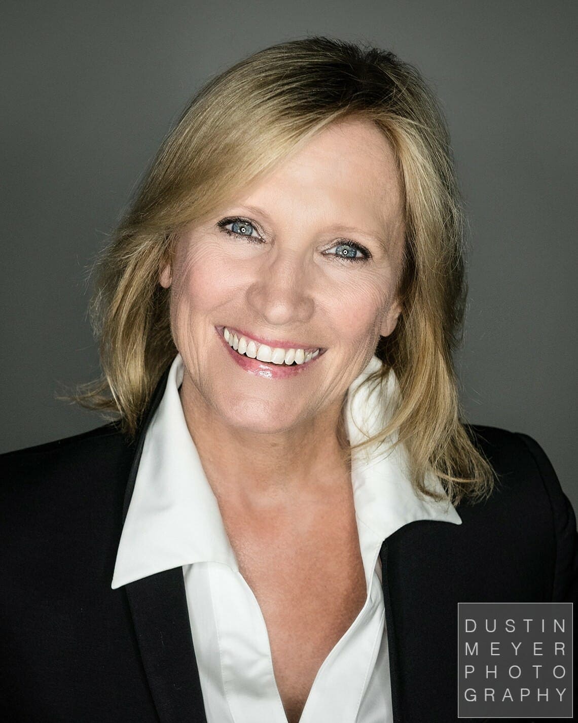 professional headshot tips a blonde woman in a black business jacket and white shirt 